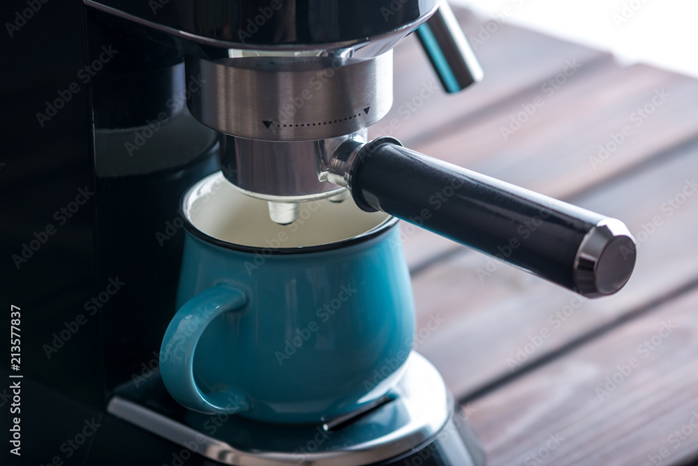 Preparation of espresso. Black coffee machine on the table. Professional coffee brewing at home Preparation of espresso. Black coffee machine on the table. Professional coffee brewing at home