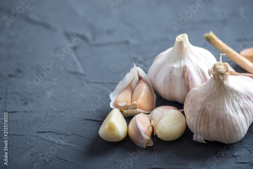 Group of garlic cloves scattered on a dark background. Important ingredient in cuisines of the world. Healthy product.