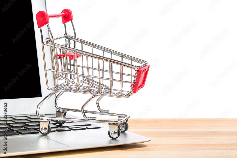 Red shopping cart on a laptop isolated on white background. Online internet shopping concept.