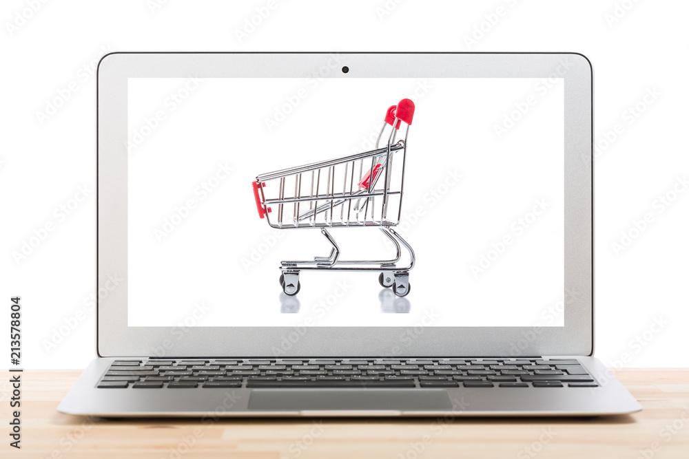 Red shopping cart on a laptop display isolated on white background. Online internet shopping concept. Red shopping cart on a laptop display isolated on white background. Online internet shopping concept.