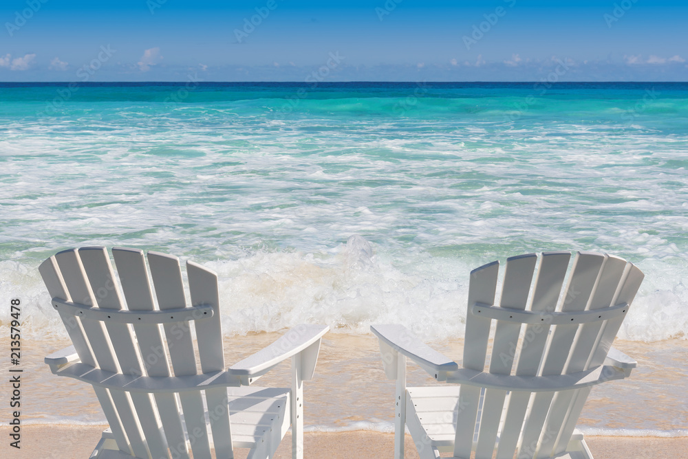 Beach chairs on sandy beach and turquoise sea.  Summer vacation and travel concept.  