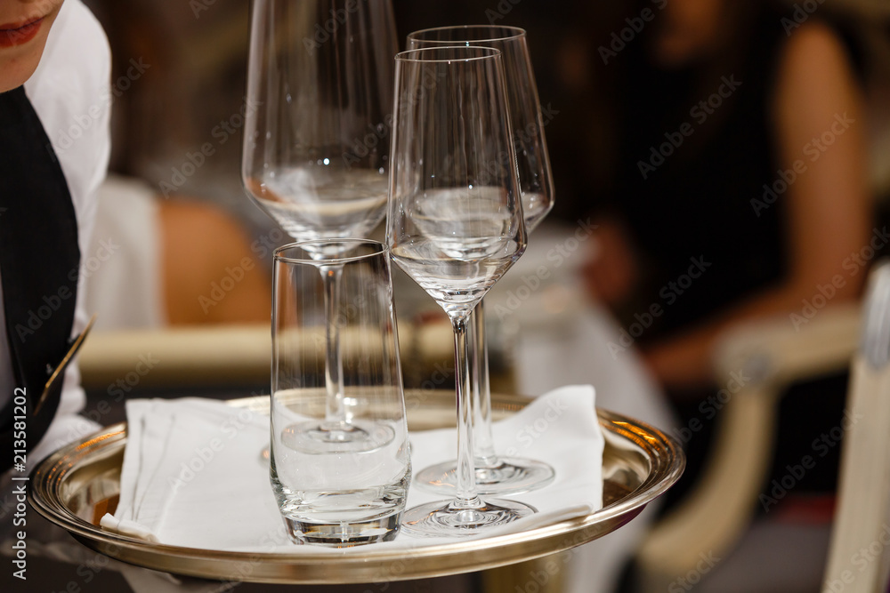 Waiter holding tray with glasses of champagne indoors