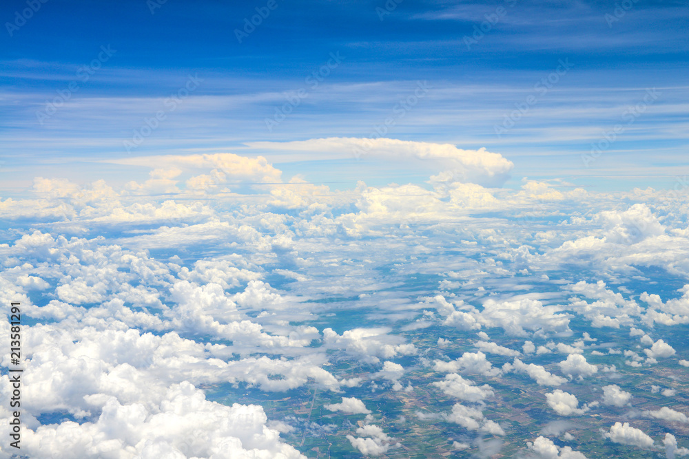Naklejka premium Beautiful view of blue sky above the white clouds and land background from airplane window