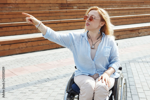 Woman in a wheelchair in the city park. The concept of an accessible environment for disabled people.