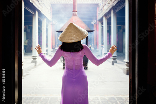 Young Vietnam woman wearing Ao Dai culture traditional at old temple at Ho Chi Minh in Vietnam,vintage style,travel and relaxing concept.