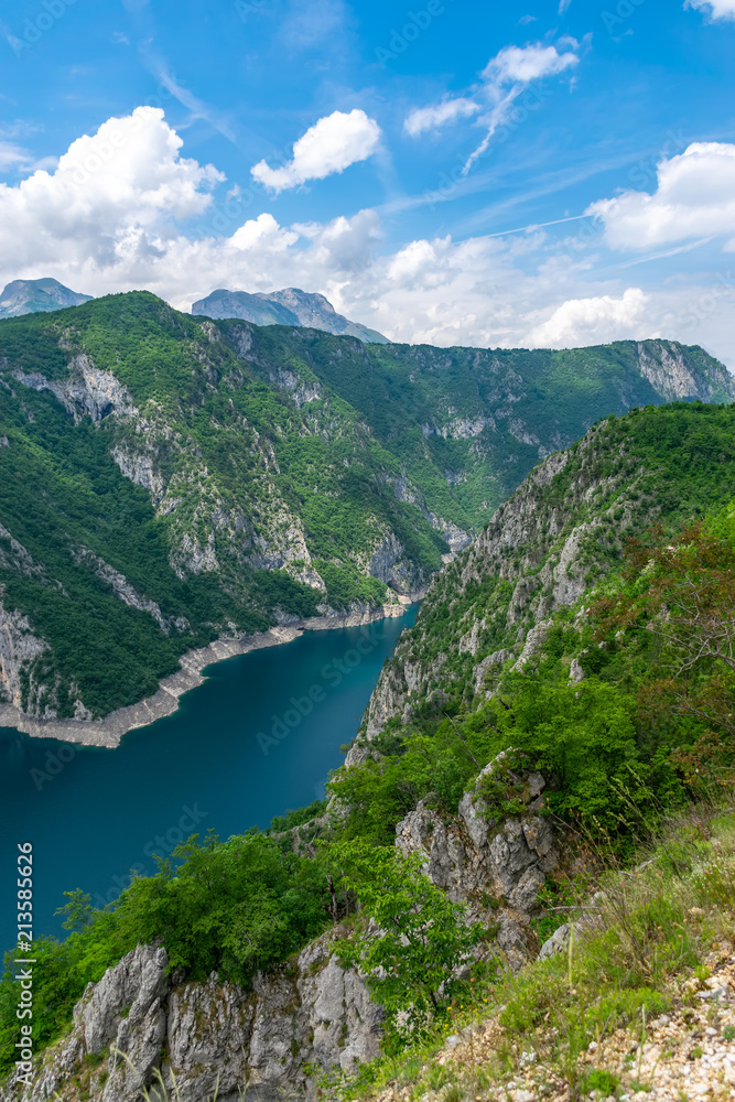 A picturesque turquoise lake can be seen from the top of a high mountain.