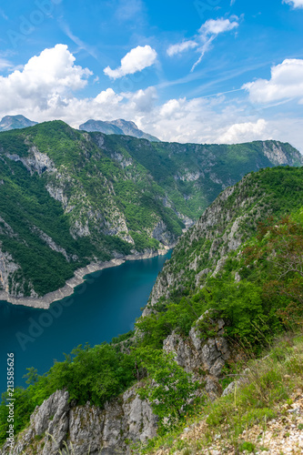 A picturesque turquoise lake can be seen from the top of a high mountain.