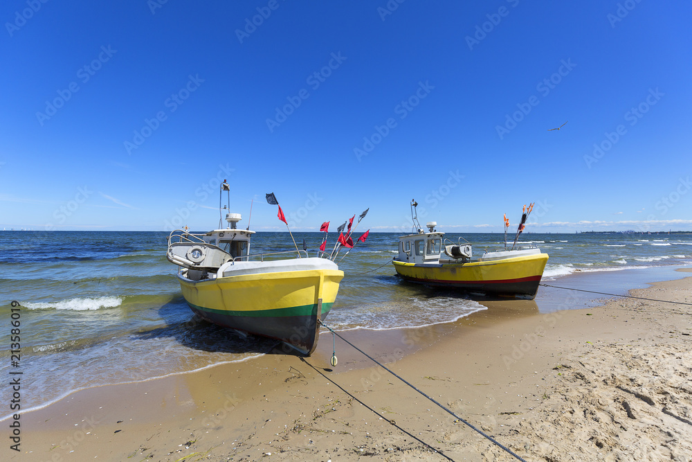 Fishing boats by the sandy beach on the Baltic Sea on a sunny day, Sopot, Poland.