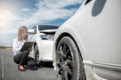 Insurance agent writing on clipboard after accident cars. © ibravery