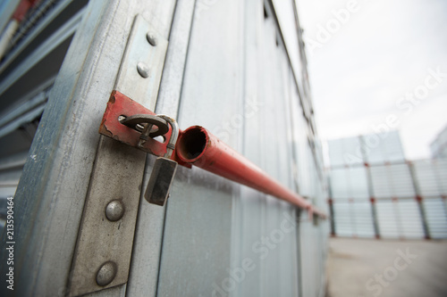 Close-up of sealed metal shipping container, hanging open lock after burglary