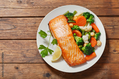 plate of baked salmon steak with vegetables