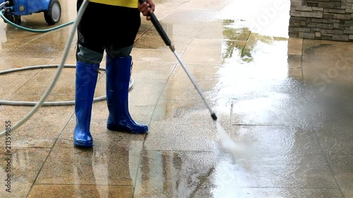Outdoor floor cleaning with high pressure water jet. Focus on worker