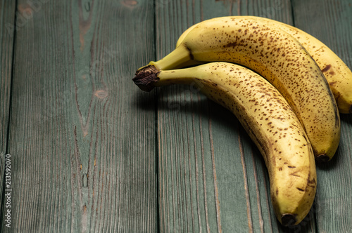 Natural texture: Sweet ripe yellow bananas on a green wooden background.