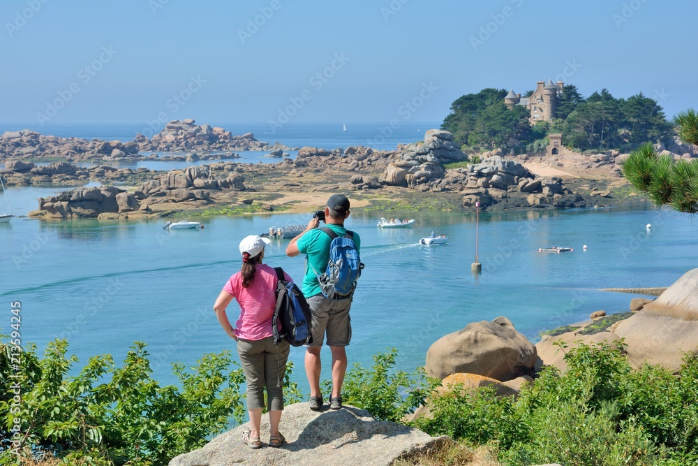 Des touristes qui admirent la magnifique côte de granit rose à Ploumanach en Bretagne. France