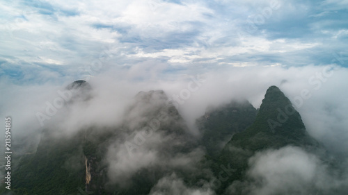 aerial view of cloudscape above farmland, river and roll of hills