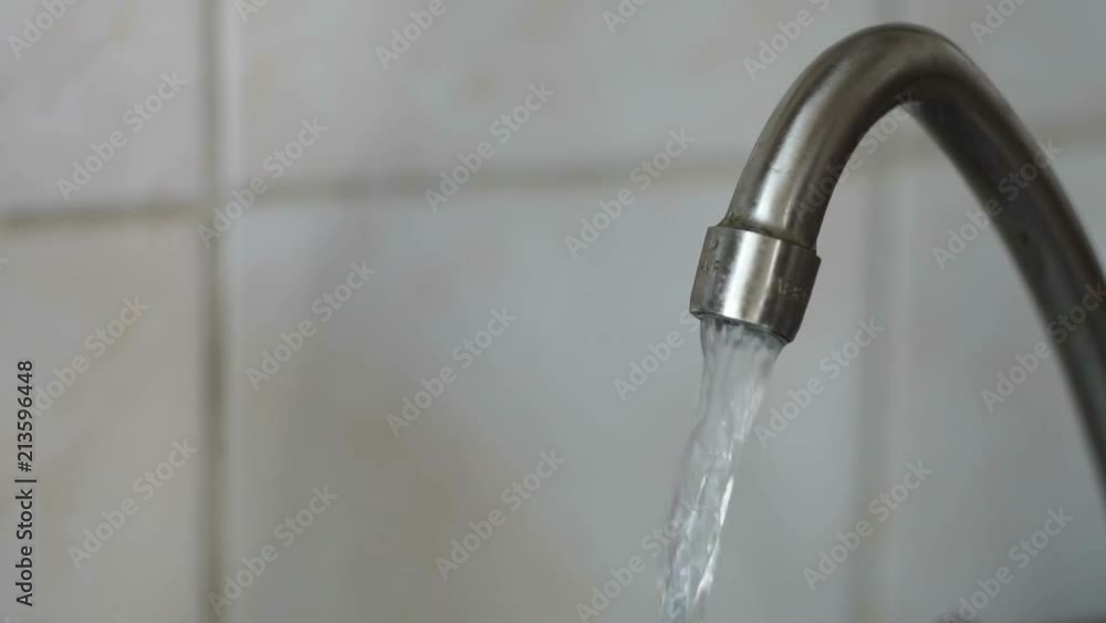 Water under weak pressure flows from a water tap Water under weak pressure flows from a water tap