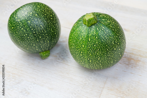 Two round zucchini on wooden background