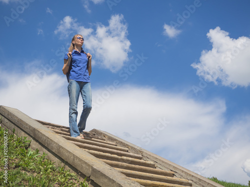Woman down the stairs against the blue sky.