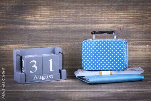 31 August, wooden square calendar. suitcase bag for traveling, stylish accessory. business trip or holiday planning background photo