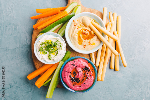 Fresh vegetarian dips in small bowls on table photo