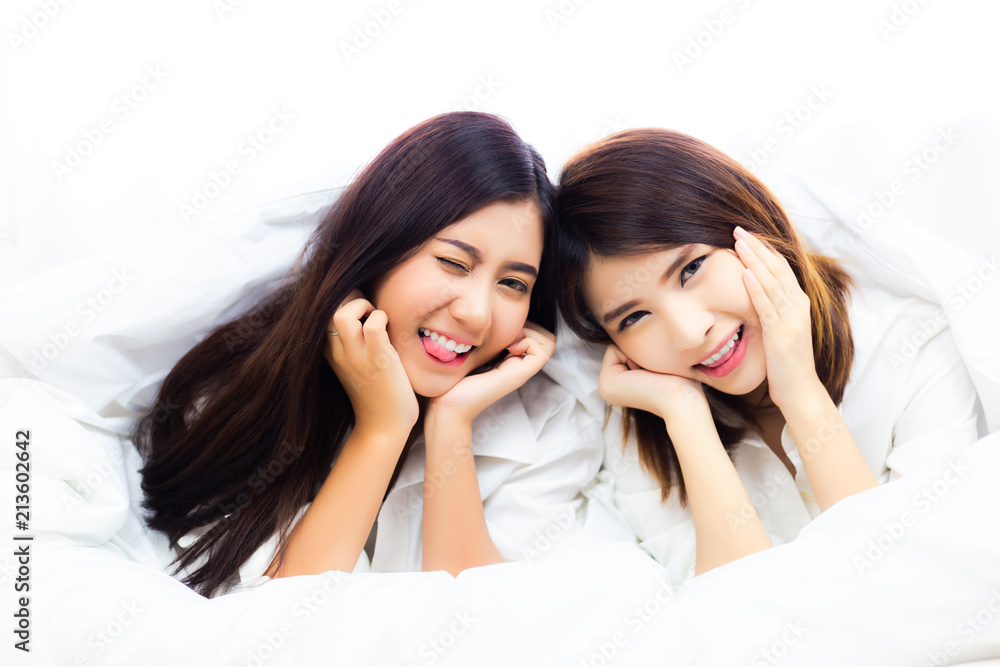 Portrait charming beautiful women. Attractive beautiful girls are best  friend or close friend. Lovely friend is playing together on a bed at  bedroom. Asia women make funny face. They're happiness Stock Photo |