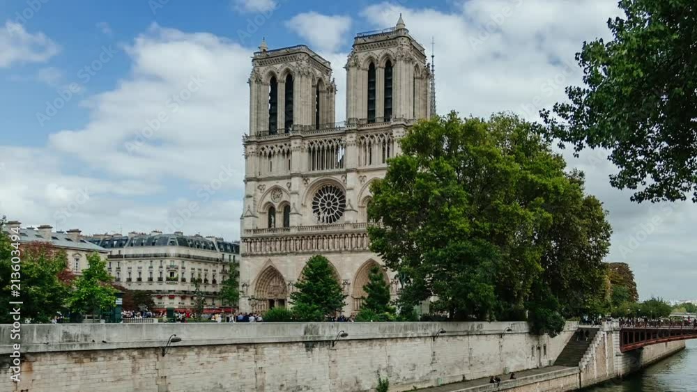 Time lapse of ancient catholic cathedral Notre-Dame de Paris on summer cloudy day. Quays of the Seine river with boats. Water traffic, famous touristic places and popular travel destinations in Europe Time lapse of ancient catholic cathedral Notre-Dame de Paris on summer cloudy day. Quays of the Seine river with boats. Water traffic, famous touristic places and popular travel destinations in Europe
