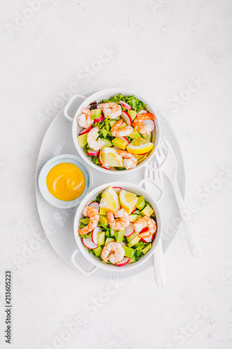Salad with prawns in bowls on table
