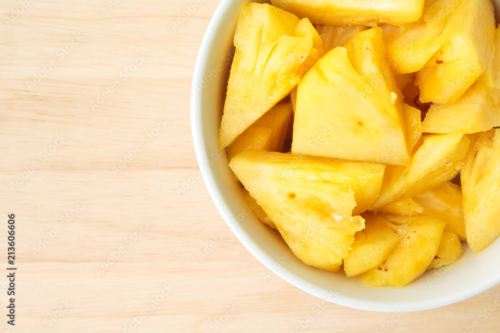 Pineapple on a plate placed on a wooden table. Pineapple on a plate placed on a wooden table.