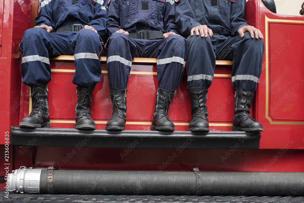 Fototapeta premium jeunes pompiers sur un camion de collection français