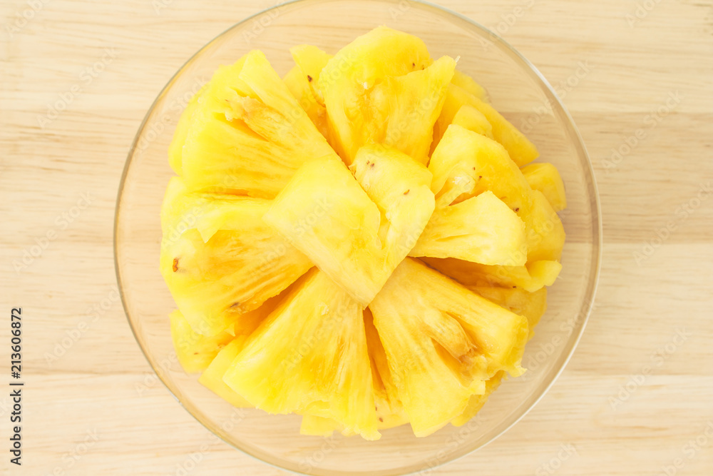 Pineapple on a plate placed on a wooden table. Pineapple on a plate placed on a wooden table.