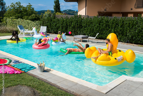 Friends having fun in a swimming pool photo