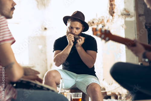 Repetition of rock music band. Electric guitar player and drummer behind the drum set.