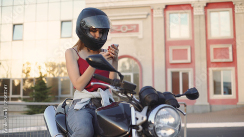 beautiful young red-haired woman motorcyclist with black motorcycle helmet photo