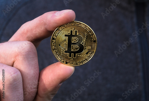 The man stretches a bitcoin, bitcoin in the hand, open palm with bitcoin