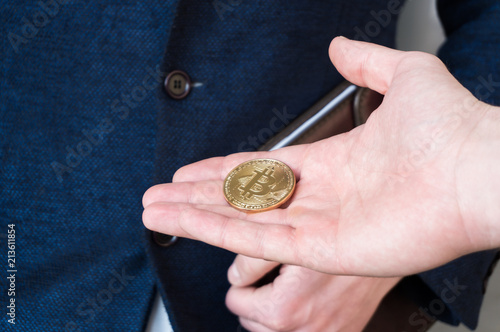 The man stretches a bitcoin, bitcoin in the hand, open palm with bitcoin