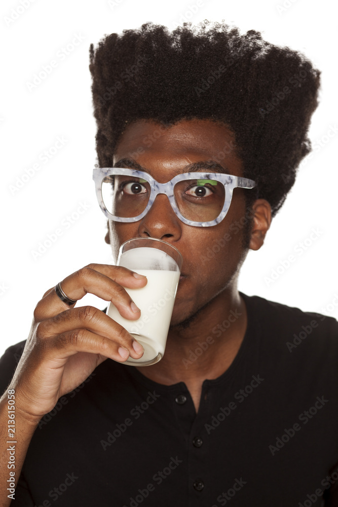 Portrait of young african american man drinking yogurt from a glass on white background Portrait of young african american man drinking yogurt from a glass on white background