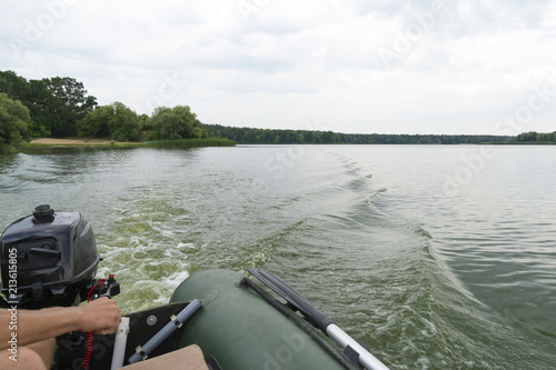 Male hands and Motorboat on the lake
