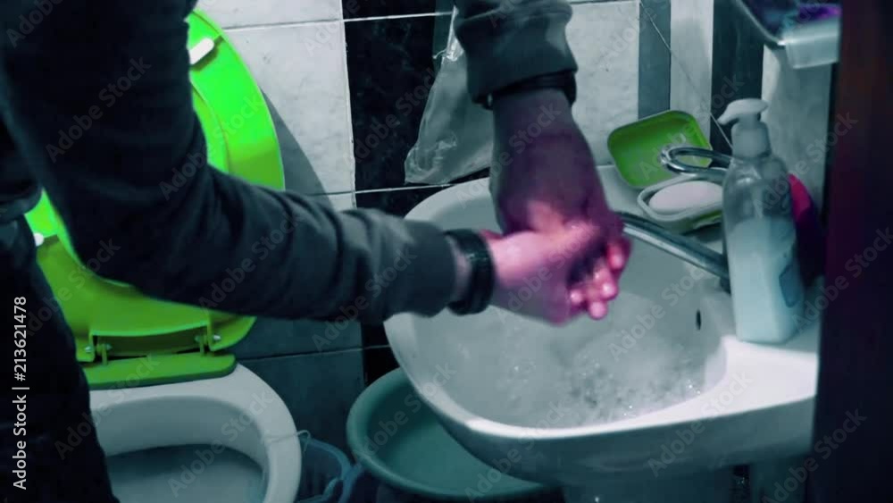 A Man Washes his Hands in the Bathroom A Man Washes his Hands in the Bathroom