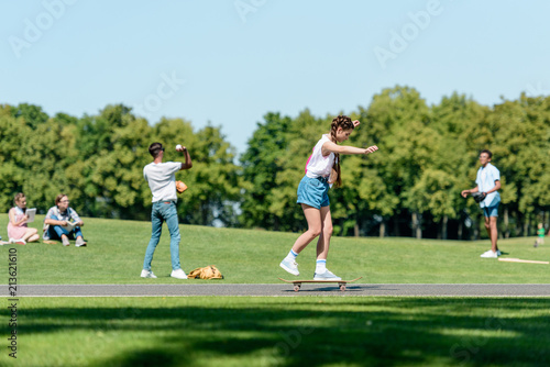 multiethnic group of teenagers spending time together in park