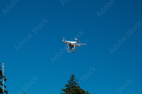 White quadrupter with propellers flies in the sky and photographs landscapes photo