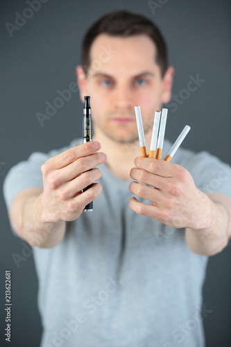 Wallpaper Mural Man holding cigarettes in one hand and an electronic cigarette in the other hand Torontodigital.ca