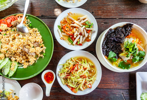 Group of Food Som Tam,Tum Lai Bua or Lotus Root Salad, Pork Stir Rice and Seaweed Soup with Pork on Wood Table.