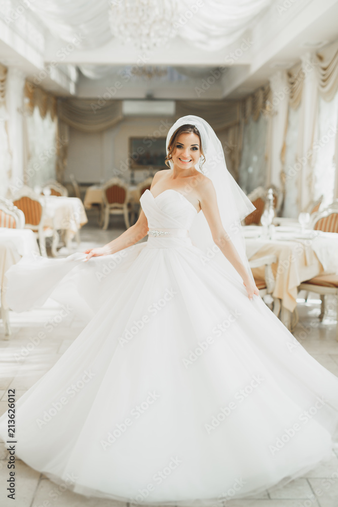 Beautiful bride posing in wedding dress in fashion hotel Beautiful bride posing in wedding dress in fashion hotel