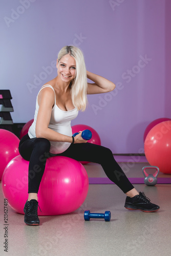 Beauty sporty pregnant woman working out in gym with balls on the background