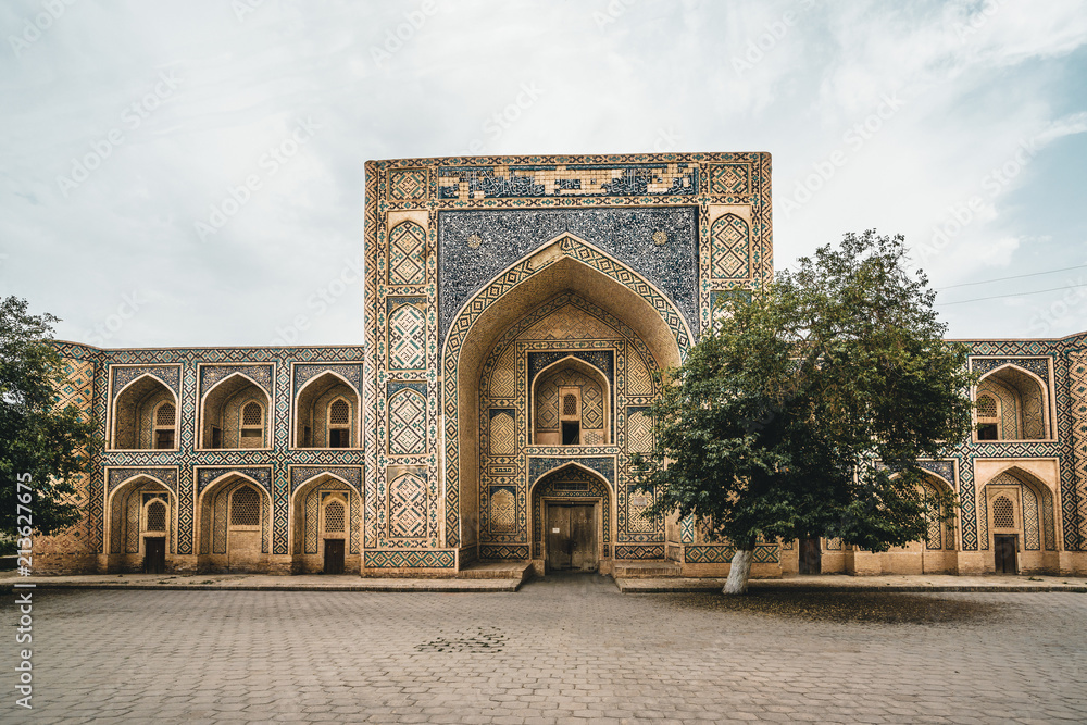 Fototapeta premium Abandoned Madrasa with tree in Bukhara Uzbekistan