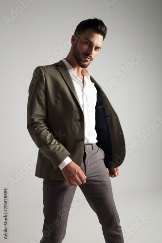 sexy young man with undone green suit standing