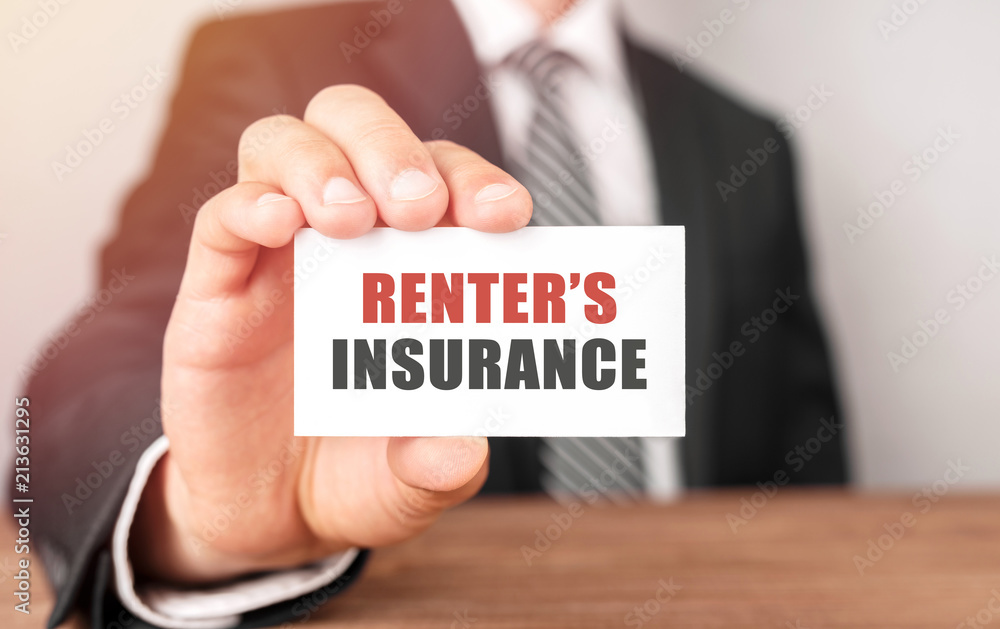 Businessman holding a card with text Renter's insurance Businessman holding a card with text Renter's insurance
