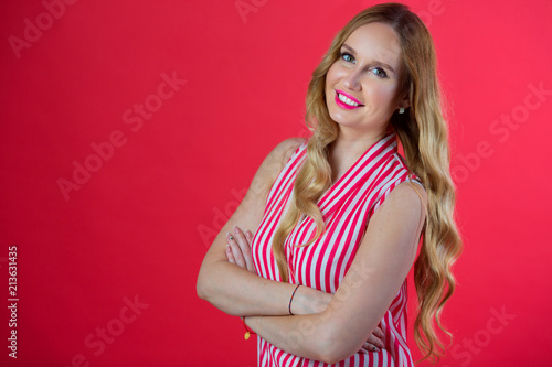 beautiful young woman in a bright shirt on a red background