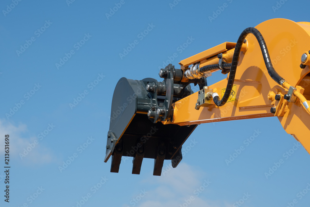 Arm of earth excavating equipment with blue sky in background