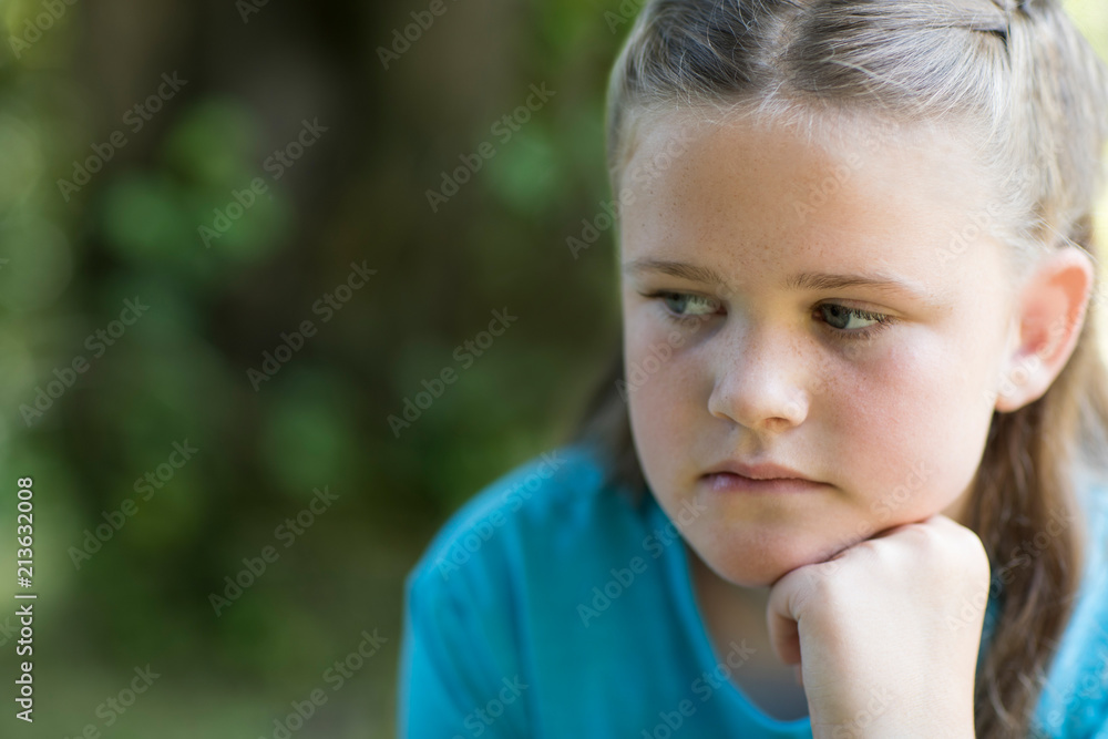Close Up Of Unhappy Girl Sitting Outdoors In Garden Close Up Of Unhappy Girl Sitting Outdoors In Garden